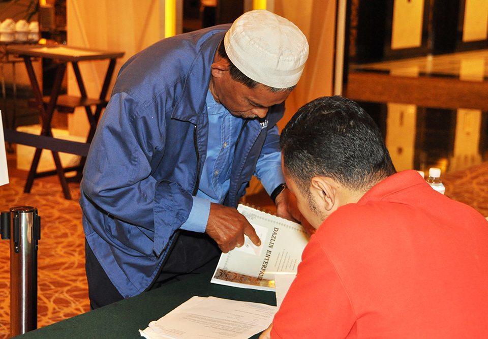 CHECKING CLOSELY: A Bumiputera contractor is looking for his company's name.
