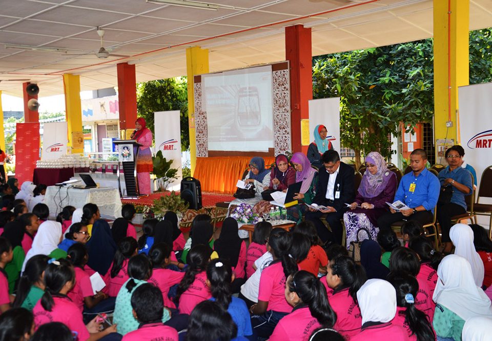 Pelajar bersedia untuk mendengar ucapan oleh Guru Besar Puan Khatijah Yusof (duduk, tiga dari kiri) and Pengarah Komunikasi Strategik dan Perhubungan Awam MRT Corp, Encik Amir Mahmood Razak (duduk, tiga dari kanan).
