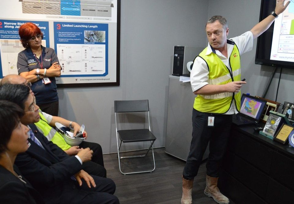 MENGENALI PROJEK: Pengarah Bawah Tanah MRT Corp Encik Keith Allenby (berdiri) berkongsi maklumat tentang projek MRT kepada Menteri Tanah, Infrastruktur, Pengangkutan dan Pelancongan Jepun Encik Keiichi Ishii (duduk berpakaian sut).