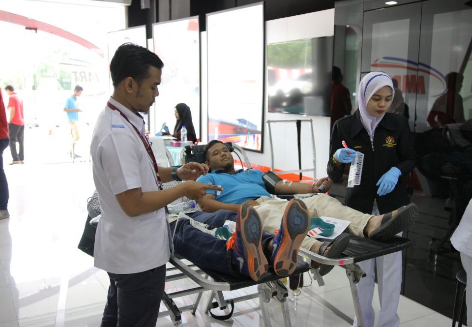 MEMBERI BANTUAN: Warga kerja Pusat Darah Negara membantu penderma darah di Pusat Informasi MRT, Sri Kembangan.