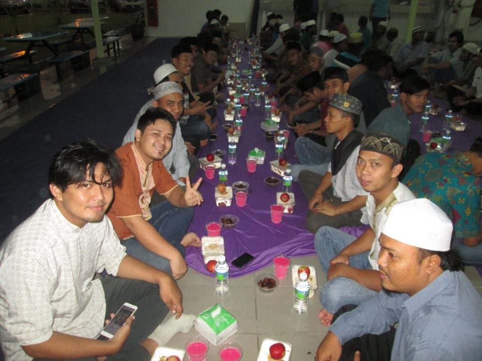 SEDAP: Pekerja asing menikmati juadah yang diberikan untuk berbuka puasa kepada mereka.