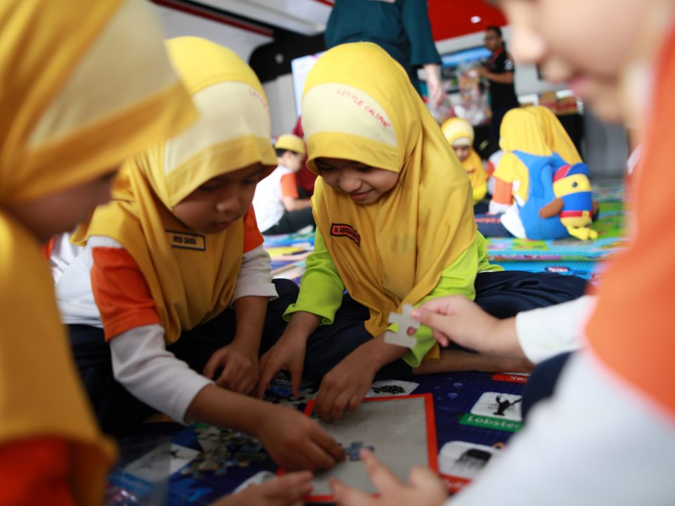 PERHATIAN PENUH: Kanak-kanak Little Caliphs Sentul menyelesaikan susun suai gambar sebuah stesen untuk MRT Laluan Sungai Buloh-Serdang-Putrajaya.