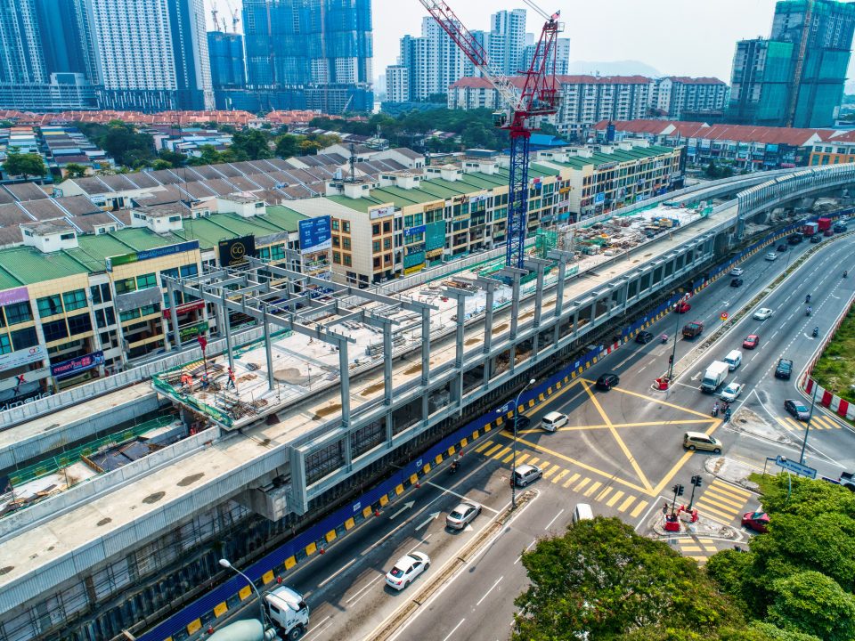 Pandangan udara kerja-kerja pemasangan kerangka atas struktur besi sedang dijalankan di Stesen MRT Metro Prima. Kerja-kerja yang telah siap untuk rasuk, papak dan tiang di paras platform juga boleh dilihat.