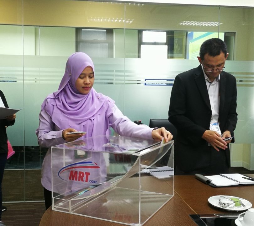CABUTAN: Cik Ramzahidah dari MMC Gamuda KVMRT (PDP SSP) Sdn Bhd memasukkan nama ke dalam kotak undi semasa Cabutan Undian Bumiputera MRT Laluan Sungai Buloh-Serdang-Putrajaya yang ke-24.