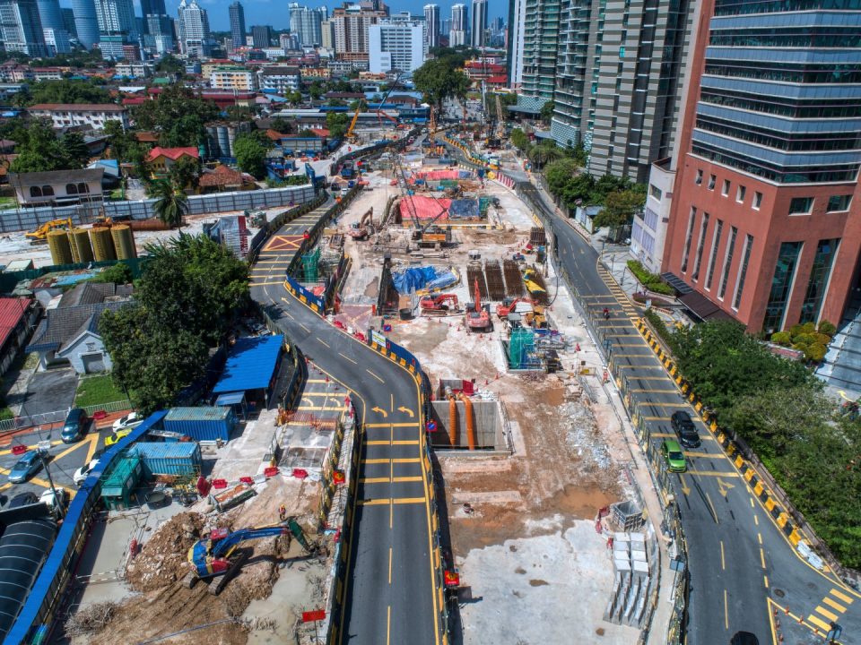 Pandangan udara tapak Stesen MRT Raja Uda menunjukkan kerja-kerja konkrit tetulang dan penggalian sedang dijalankan.