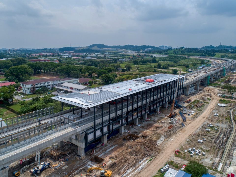 Pandangan udara tapak Stesen MRT UPM menunjukkan pemasangan kekuda bumbung dan struktur besi sedang dijalankan.