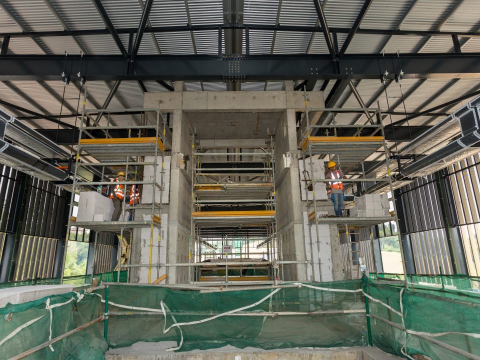 Tembok bata untuk kemasan seni bina bagi sokong penaik bersebelahan teras lif sedang dijalankan di aras platform Stesen MRT Taman Naga Emas