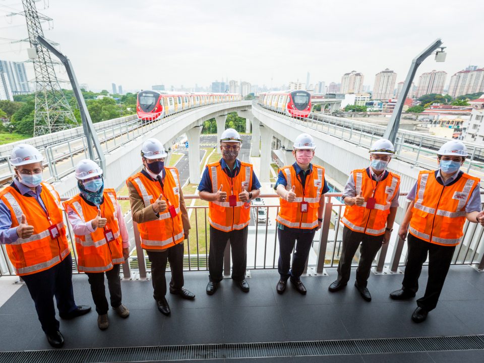 SEMUA BAIK: Delegasi pemeriksaan ketersediaan operasi MRT Laluan Putrajaya Fasa Satu memberikan tanda semua baik dengan latar belakang tren MRT dan pandangan panorama Kuala Lumpur. Dari kiri ke kanan: Ketua Pengarah Agensi Pengangkutan Awam Darat Encik Azlan Shah Al Bakri, Timbalan Ketua Setiausaha Kementerian Pengangkutan Puan Normah Osman, Timbalan Menteri Kewangan I Datuk Abd Rahim Bakri, Ketua Setiausaha Kementerian Pengangkutan Datuk Isham Ishak, Menteri Pengangkutan Datuk Seri Ir. Dr. Wee Ka Siong, Datuk Bandar Kuala Lumpur Datuk Seri Mahadi Che Ngah, dan Ketua Pegawai Eksekutif MRT Corp Datuk Mohd Zarif Hashim.