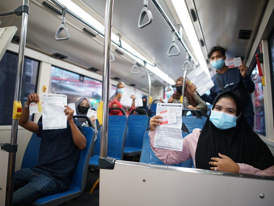DIVAKSINASI: Penduduk PPR Lembah Subang menunjukkan bukti vaksinasi mereka semasa perjalanan pulang ke kediaman mereka menaiki Bas Perantara MRT Laluan Putrajaya