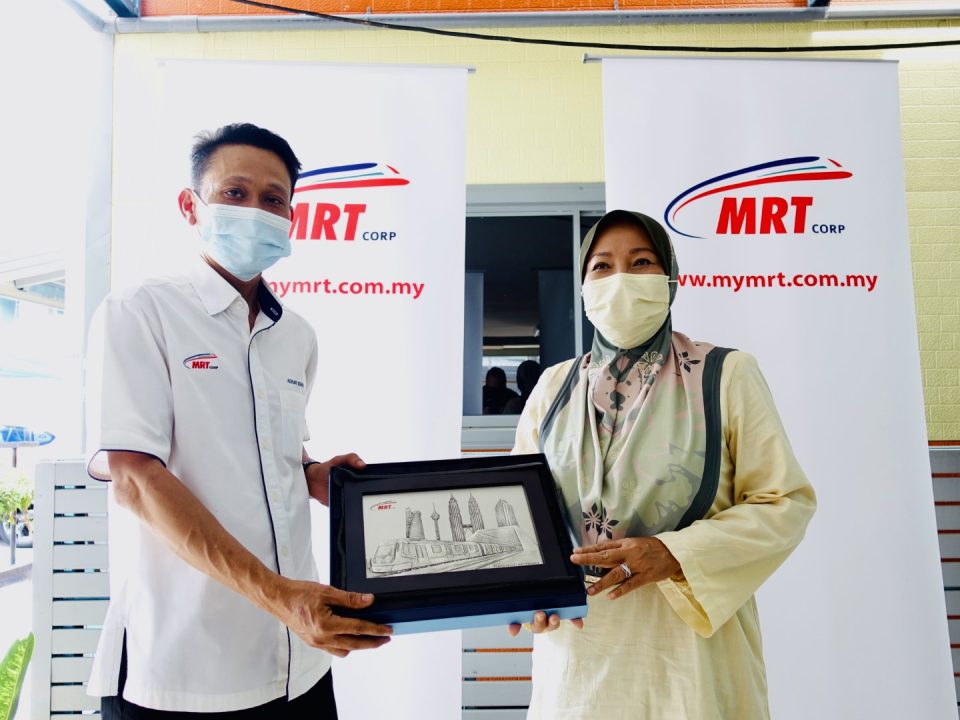 MEMENTO: Pemangku Ketua Pematuhan dan Piawaian MRT Corp Encik Azhar Sofah menyerahkan sebuah memento kepada Datuk Bandar Majlis Bandaraya Subang Jaya, TPr. Hajah Noraini Haji Roslan sebagai tanda penghargaan di atas masa dan ilmu yang dikongsi, semasa kunjungan beliau ke Kuarters Pekerja Setempat V206 Serdang.